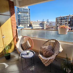 2 stoelen en een tafel op een balkon met uitzicht bij Shpetim's Apartment in Pristina