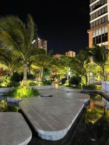 un parco con palme e una piscina di notte di Cathy’s Hidden Charm a Hanoi