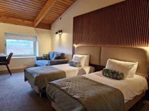 een hotelkamer met 2 bedden en een bank bij Dorset Resort Hotel in East Stoke