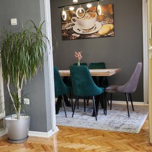 uma sala de jantar com uma mesa e cadeiras verdes em Shpetim's Apartment em Pristina