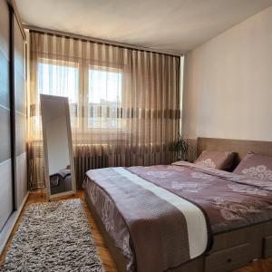 a bedroom with a large bed and a window at Shpetim's Apartment in Pristina