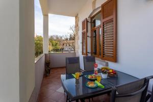 a dining room with a table and chairs on a balcony at Apartman LeMa in Pula