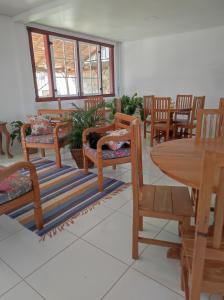 una habitación con sillas de madera y una mesa con un gato durmiendo en un banco en Pedacinho do céu en Tiradentes