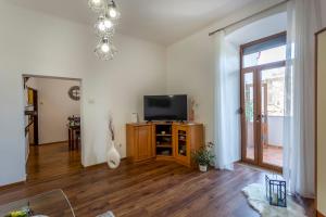 a living room with a flat screen tv on a wooden cabinet at Apartman LeMa in Pula
