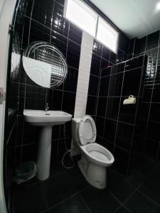 a black tiled bathroom with a toilet and a sink at Modern resort..โมเดิร์นรีสอร์ท in Thang Kwian
