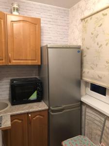 a small kitchen with a refrigerator and a microwave at Ahtme mnt apartaments in Ahtme