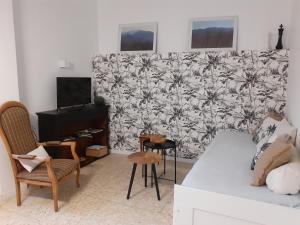 ein Wohnzimmer mit Tisch und Stühlen und einer Wand in der Unterkunft Agréable maison de village avec terrasse in Vinça + 29 Fotos