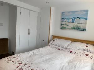 a bedroom with a bed and a painting on the wall at One bedroom self contained annex with own bathroom, sitting room and kitchenette in Emsworth