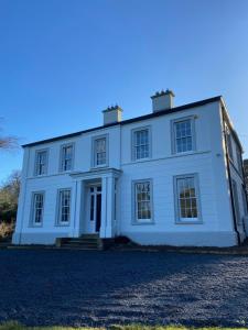 a large white house on top of a driveway at Ashville Georgian House in Killinchy