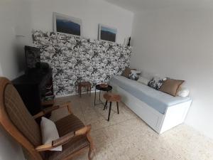 ein Wohnzimmer mit einem Sofa und einer Wand in der Unterkunft Agréable maison de village avec terrasse in Vinça