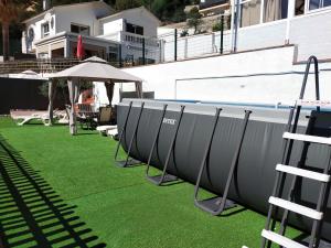 szereg basenów i parasoli na trawie obok budynku w obiekcie Espacio Kybalion w mieście Argentona