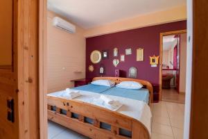 a bedroom with two beds and a purple wall at Big house with a huge garden and barbecue area! in Flogita