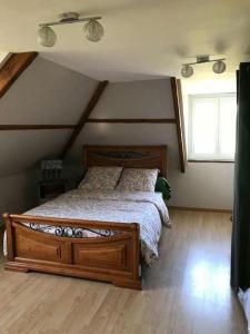 a bedroom with a wooden bed in a attic at Le Sapin in Audrehem