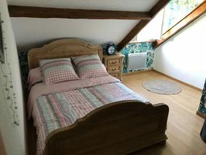 a bedroom with a bed and a dresser in a attic at Le Sapin in Audrehem