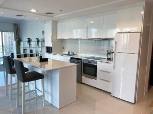 a kitchen with white cabinets and a white refrigerator at One bedroom apartment with pool & gym near Marina in Dubai