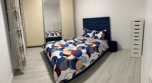 - une chambre avec un lit, une couette et un miroir dans l'établissement Lectorului Residence 3 rooms Colosseum Mall, à Bucarest