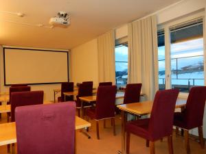 a classroom with tables and chairs and a whiteboard at Grand Hotell Bollnäs in Bollnäs