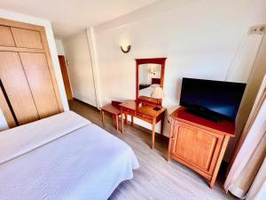 a hotel room with a bed and a flat screen tv at Hotel Nadal in Benidorm