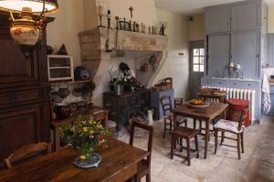 uma sala de estar com mesas e cadeiras e uma lareira em La Maison de la Tour em Semur-en-Auxois