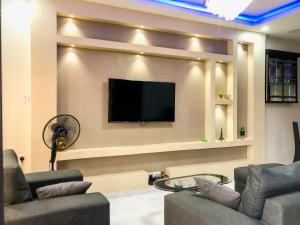 a living room with a flat screen tv on a wall at Crayford Homes in Ikeja