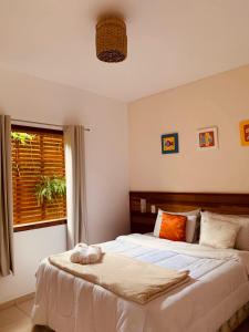 um quarto com uma cama grande e uma janela em Pousada Luamar em Paraty