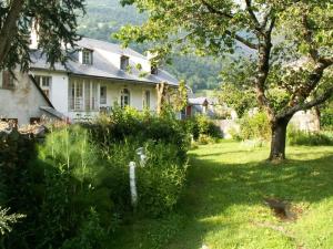 uma casa branca com uma árvore no quintal em Magnifique maison de maître du 18e avec jardin em Luz-Saint-Sauveur