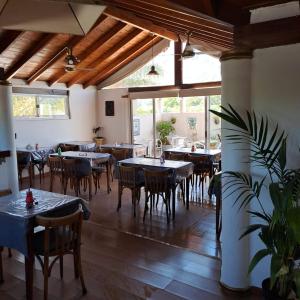 a dining room with tables and chairs and windows at Posada Del Arbol in Capilla del Monte