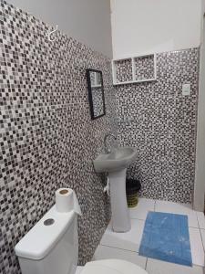 a bathroom with a white toilet and a sink at Pousada Lucrezia in Maceió