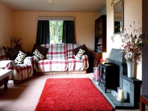 a living room with a couch and a red rug at Seal Parrock in Weathercote
