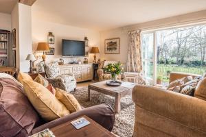 a living room with two couches and a tv at Church Farm House Campsea Ashe in Woodbridge