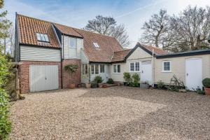 a bedroom house with a garage and a driveway at Church Farm House Campsea Ashe in Woodbridge