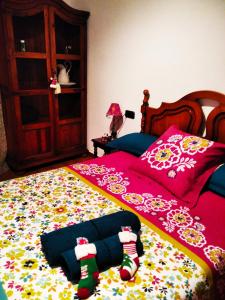 1 dormitorio con 1 cama con colcha roja y calcetines en Cal Jan, en Aixovall