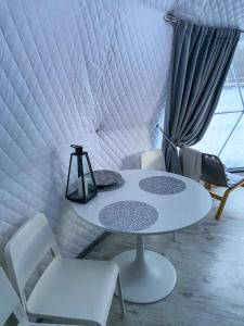 a white table and chairs in a room with a window at Glempings Anemones in Plieņciems