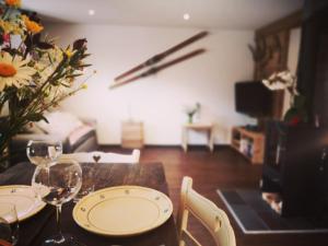 Urchige 2-Zimmerwohnung في Matten: طاولة طعام مع كؤوس نبيذ و إناء من الزهور