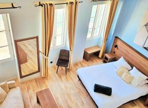 1 dormitorio con cama y espejo en Hôtel du Port en Saint-Martin-de-Ré