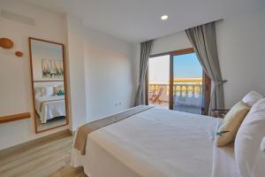 a bedroom with a bed and a mirror and a balcony at ABLANCAS - La Restinga in La Restinga +37 photos