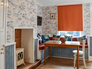 uma sala de jantar com papel de parede azul e branco em The Little House em Conwy