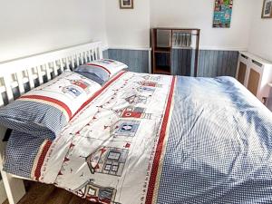 a bed with a quilt on it in a bedroom at The Little House in Conwy