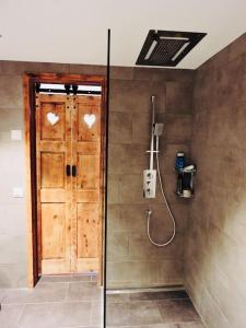 ein Badezimmer mit einer Dusche und einer Holztür in der Unterkunft Urchige 2-Zimmerwohnung in Matten