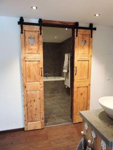 ein Badezimmer mit einer Tür, die zu einer Badewanne führt. in der Unterkunft Urchige 2-Zimmerwohnung in Matten