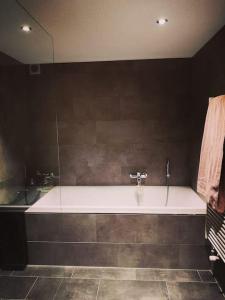 Urchige 2-Zimmerwohnung في Matten: حمام مع حوض استحمام ومغسلة