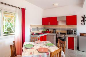a kitchen with red cabinets and a table with chairs at LAMINA Appart in Antananarivo