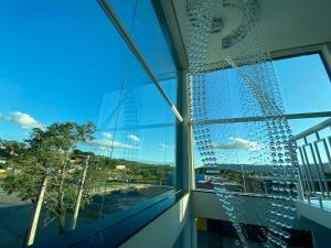 a glass building with a view of a tree at Hotel C&A in Bofete