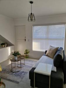 a living room with a couch and a table at Cozy 2 bedroom APT - Near Kenilworth Racecourse in Cape Town