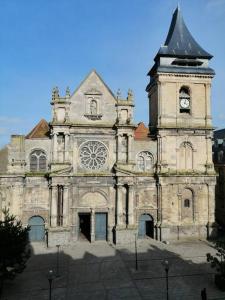 um edifício antigo com uma torre de relógio em cima em Charmant studio -Dieppe centre em Dieppe