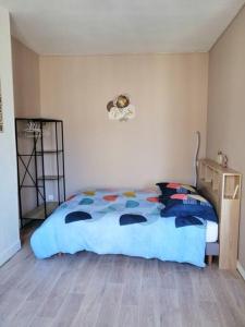 um quarto com uma cama com um edredão azul em Charmant studio -Dieppe centre em Dieppe