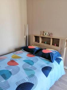 um quarto com uma cama com um edredão colorido em Charmant studio -Dieppe centre em Dieppe