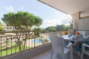 een balkon met een tafel en stoelen en uitzicht op een zwembad bij Complejo residencial-CAT 5 in Salou