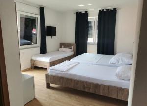 een slaapkamer met 2 bedden en een spiegel bij Rooms Ideal in Struga