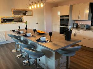 a kitchen with a large wooden island with bar stools at Kirkview in Johnshaven